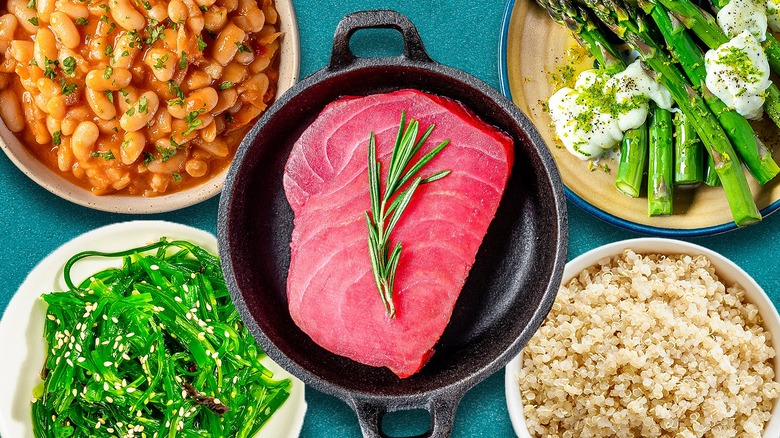 Tuna steak in a pan, surrounded by various side dishes