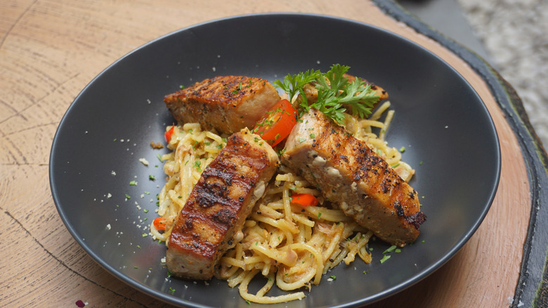 Tuna steaks served in bowl of spaghetti aglio e olio