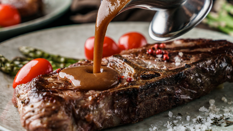 pouring sauce on grilled steak