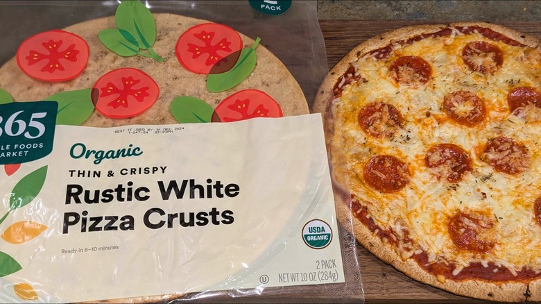 Bag of 365 brand large, brown pizza crusts next to thin-crust pepperoni pie