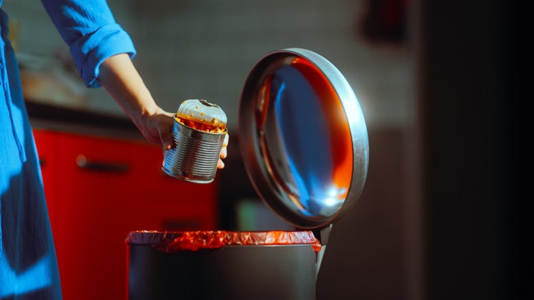 Person disposing of canned food