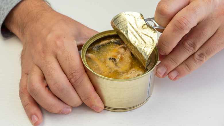 Hands opening can of food