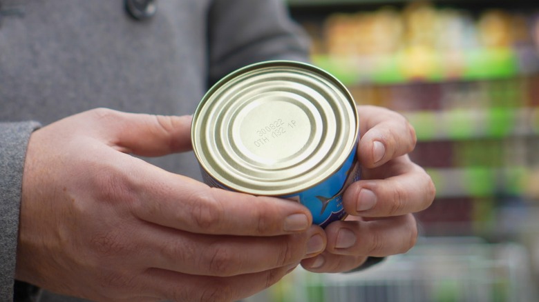 Man inspecting can of food