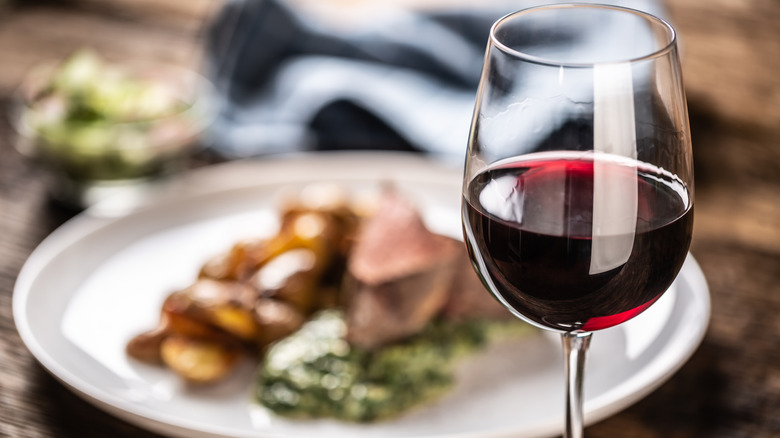 glass of wine with a steak dinner