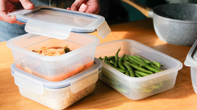 Tupperware being packed with leftover food from a photoshoot