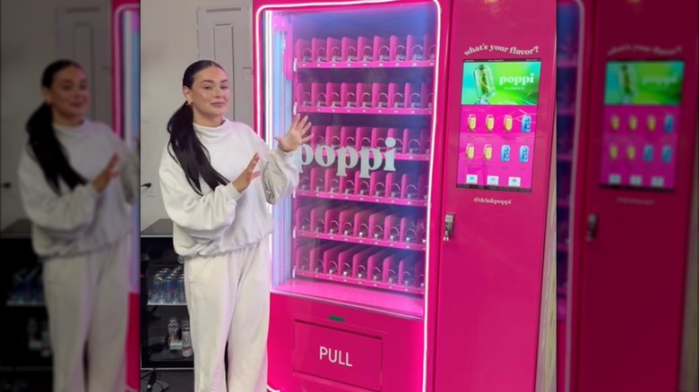 influencer Kaeli Mae posing with a Poppi vending machine