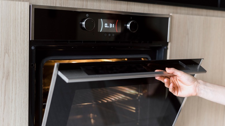 Person opening heated oven