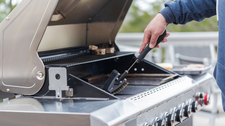 man cleaning grill