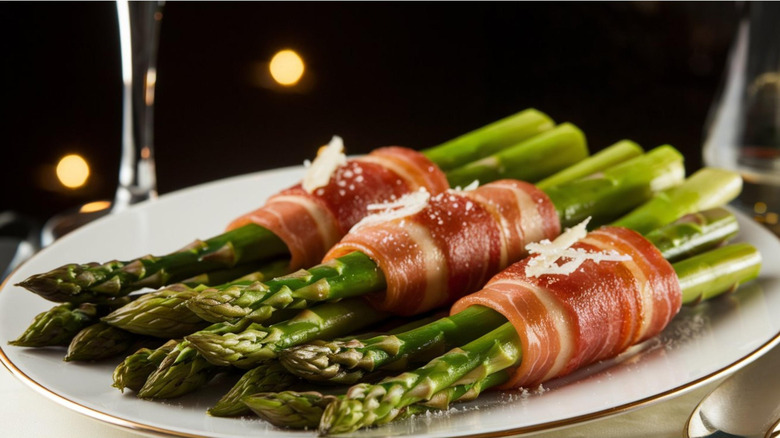 A plated appetizer of asparagus wrapped in pancetta