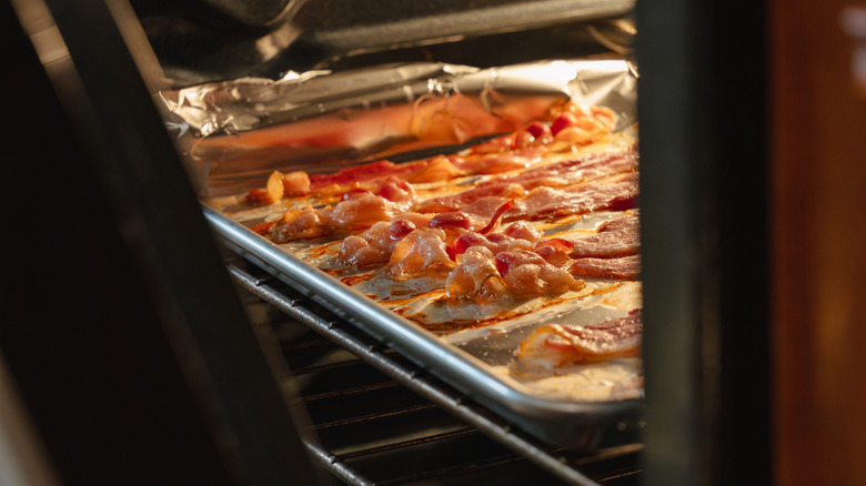 Pan sheet of bacon strips cooking in an oven