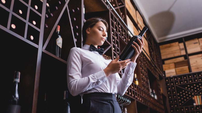 Woman inspecting a wine bottle