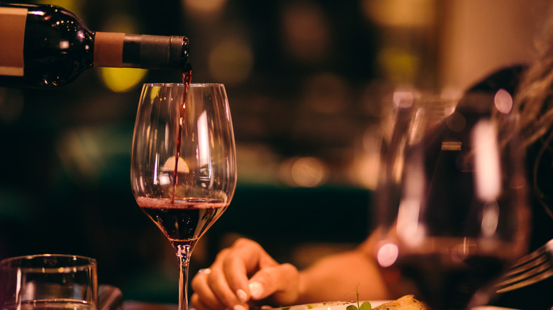 A bottle of red wine being poured