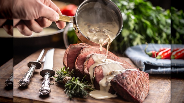 Creamy sauce poured over steak