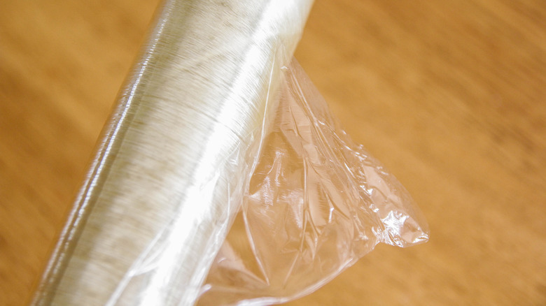 Plastic wrap roll on wooden background