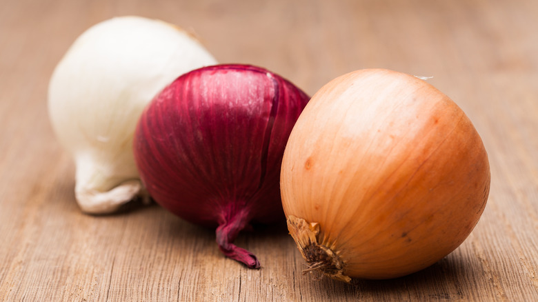 three onions on cutting board