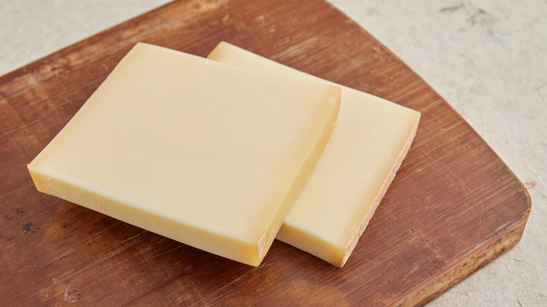 Swiss Gruyere cheese on wooden cutting board