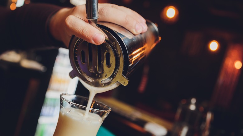 bartender using hawthorne strainer