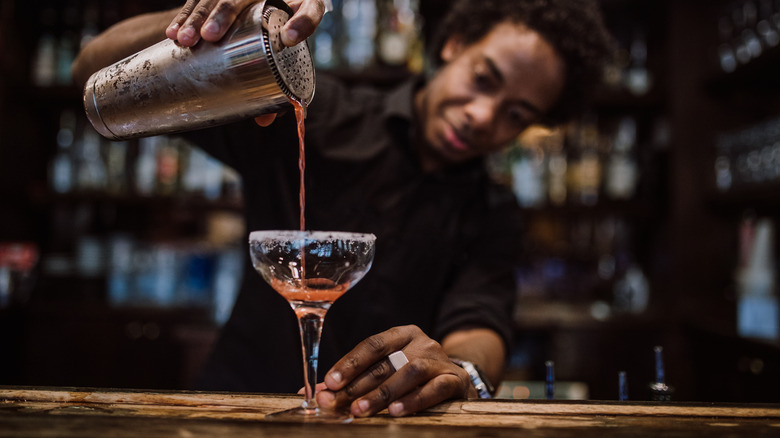 bartender using hawthorne strainer