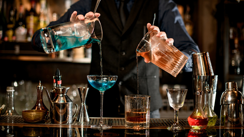 bartender straining cocktails in each hand