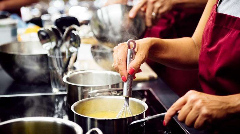 Person whisking sauce on stovetop