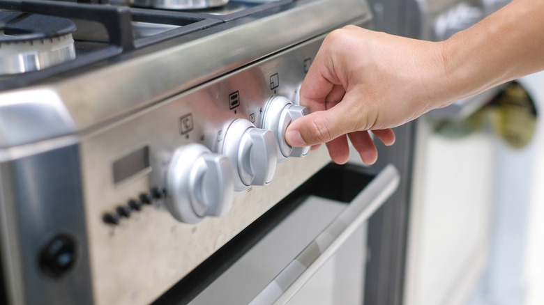 Person adjusting heat of stovetop