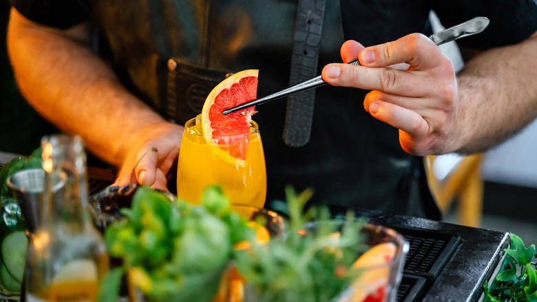 Bartender making a grapefruit cocktail