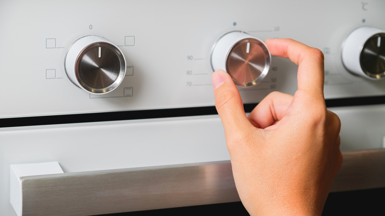 Person adjusting oven temperature