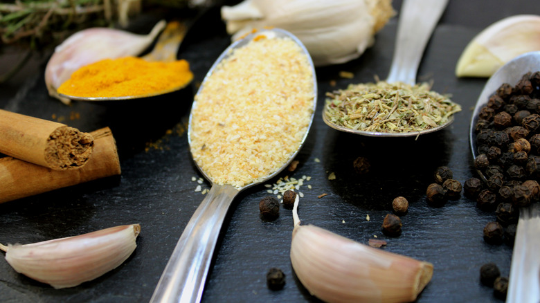 Teaspoons of garlic powder , mixed herbs, and peppercorns