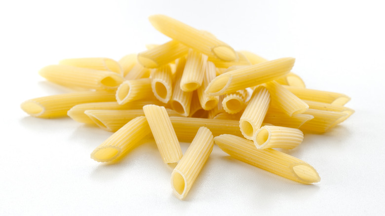 Dry penne on white background 