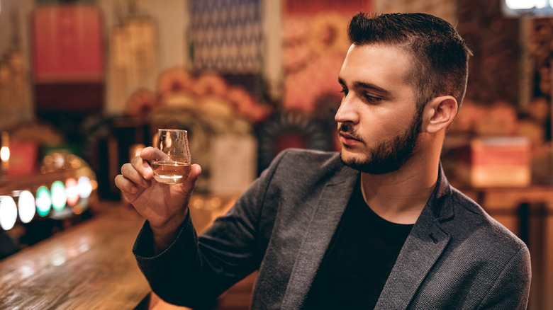 bearded man with whisky in a bar