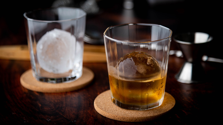 two glasses with ice ball whisky