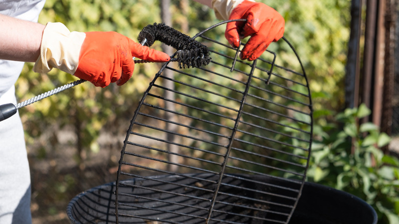 Person scraping BBQ grate