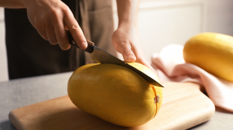 Person cutting squash in half