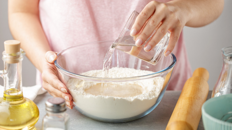 Adding warm water to dough