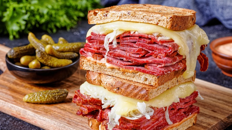 stacked Reuben sandwiches with pickles 