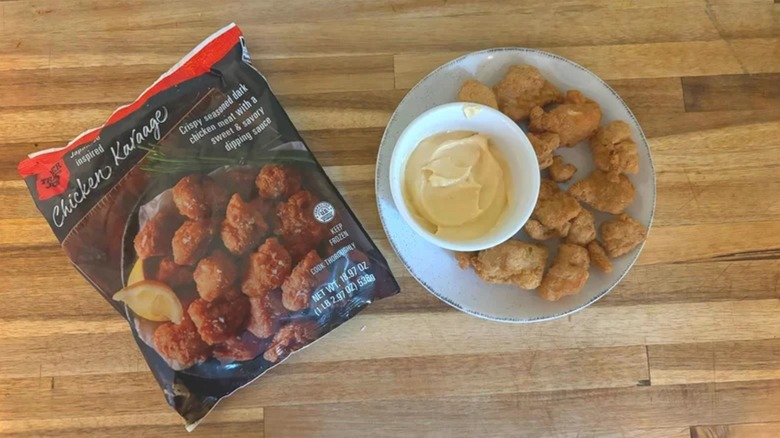 Bag of Trader Joe's Chicken Karaage next to plate of chicken karaage and sauce on wooden table