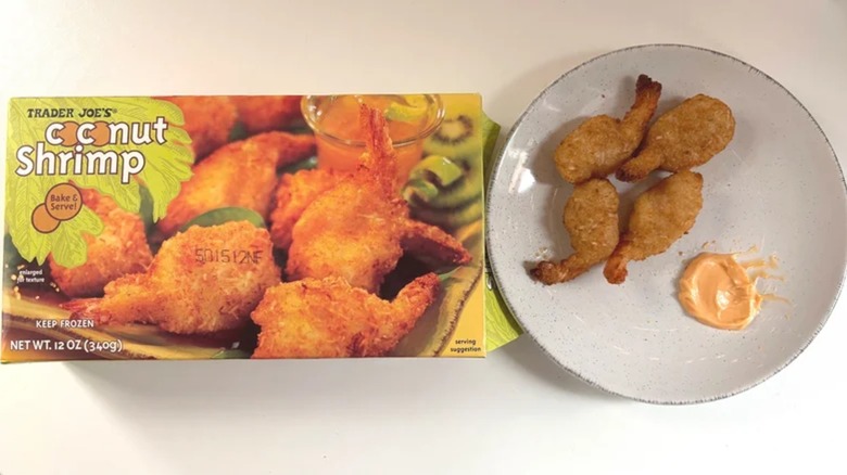 Box of Trader Joe's Coconut Shrimp next to coconut shrimp and sriracha mayo on white plate