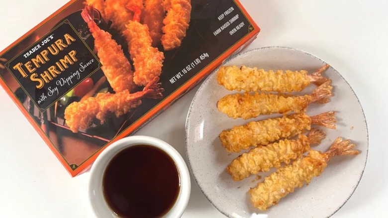 Trader Joe's Tempura Shrimp box next to white plate of shrimp and small white bowl of soy sauce