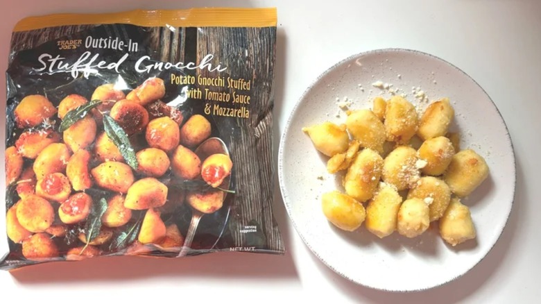 Bag of Trader Joe's Outside In Stuffed Gnocchi next to gnocchi on white plate