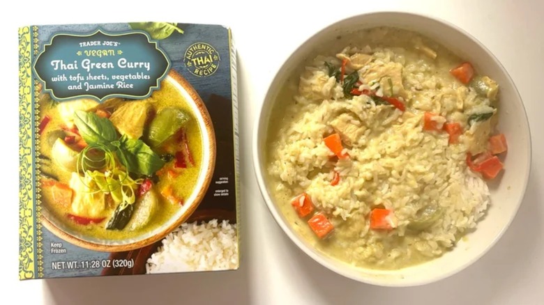 Trader Joe's Thai Green Curry box next to white bowl of green curry on white table