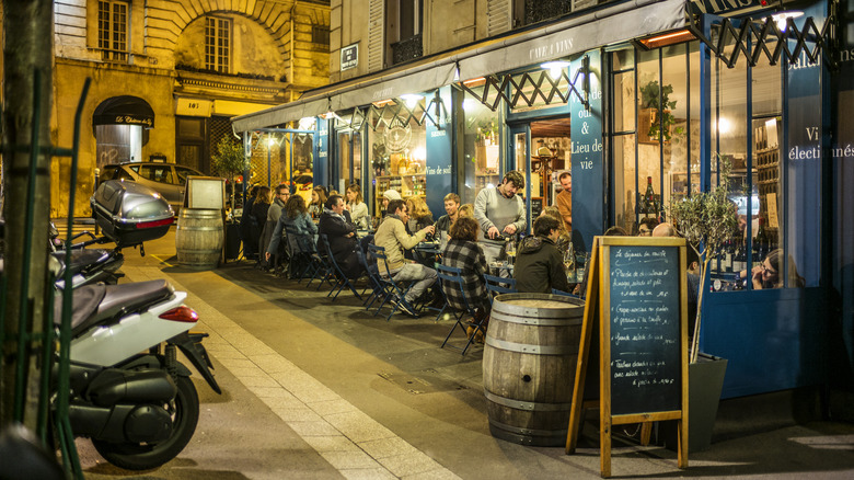 Patrons drinking wine outside of a wine bar in France