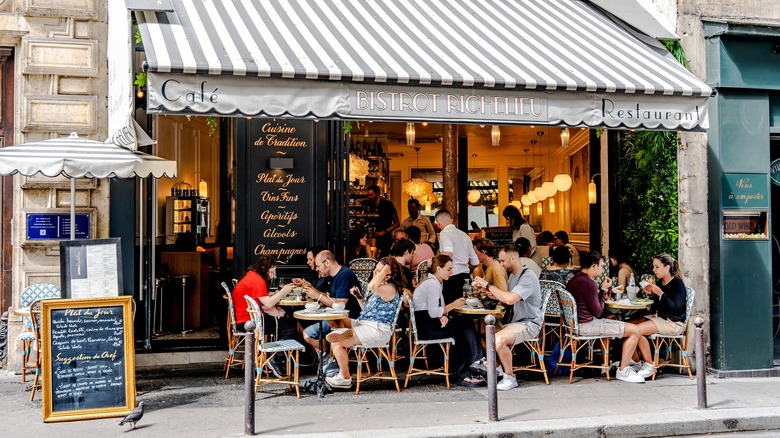 Diners eating in front of a French bistro