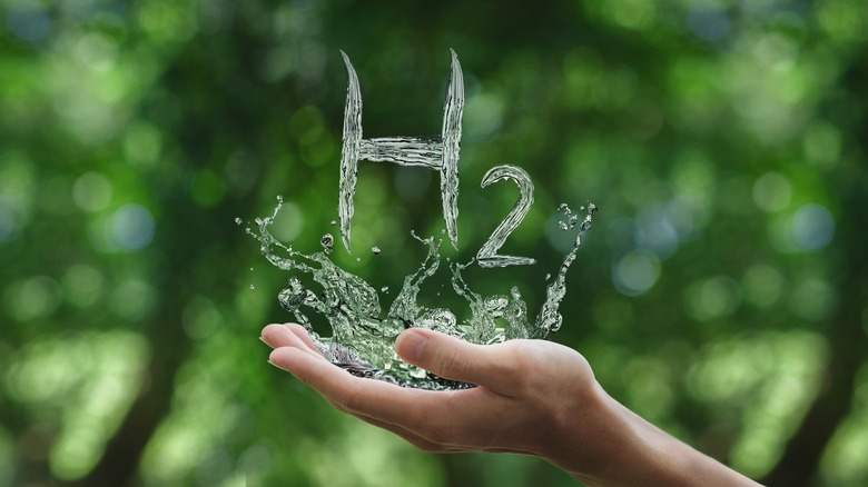 The symbol 'H2' written in water in someone's hand