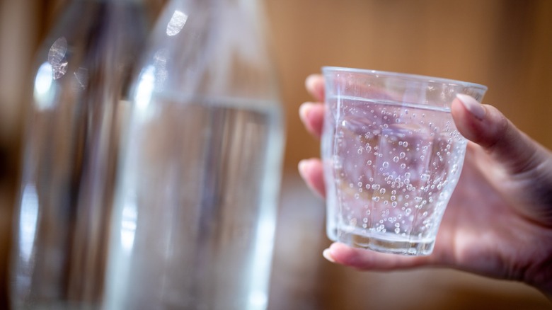 Person holding a glass of sparkling water