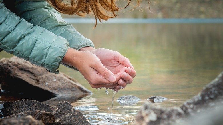 Woman scooping spring water with her hands