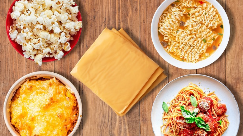 Slices of American cheese surrounded by four dishes on a wooden table