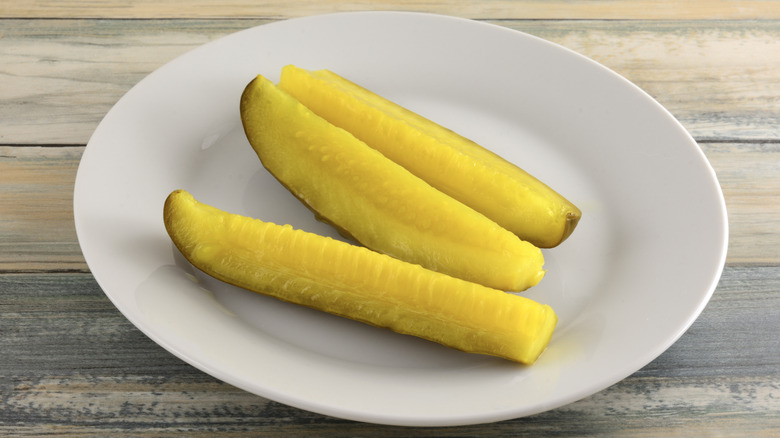 Three pickle spears on white plate