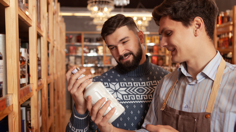 two people discussing a bottle in liquor store