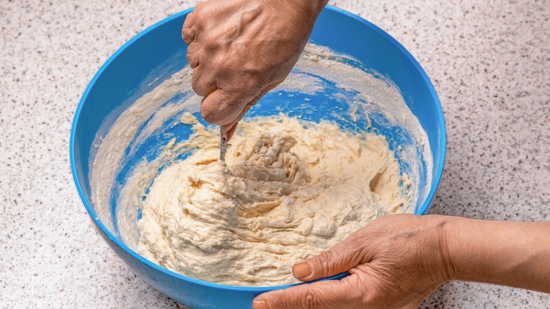 Hands in dough bowl