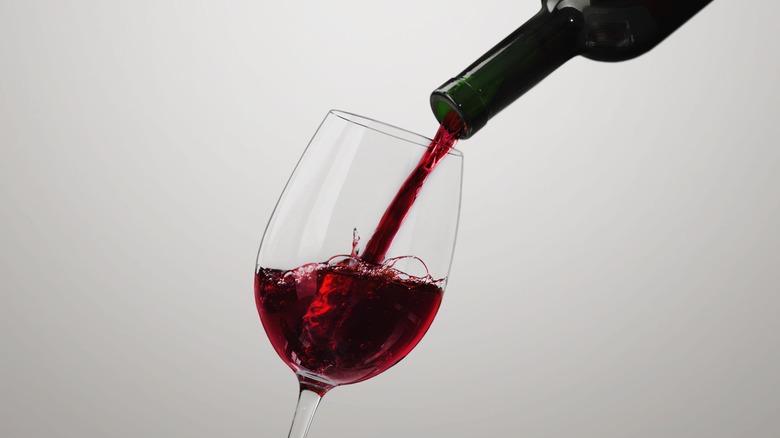 Bottle pouring red wine into glass